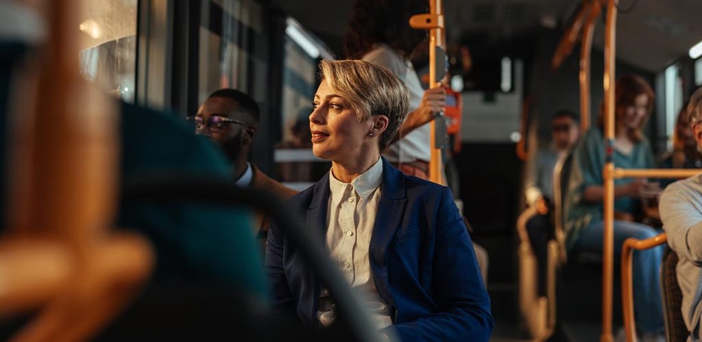 A businesswoman and other passengers travel on a city bus.