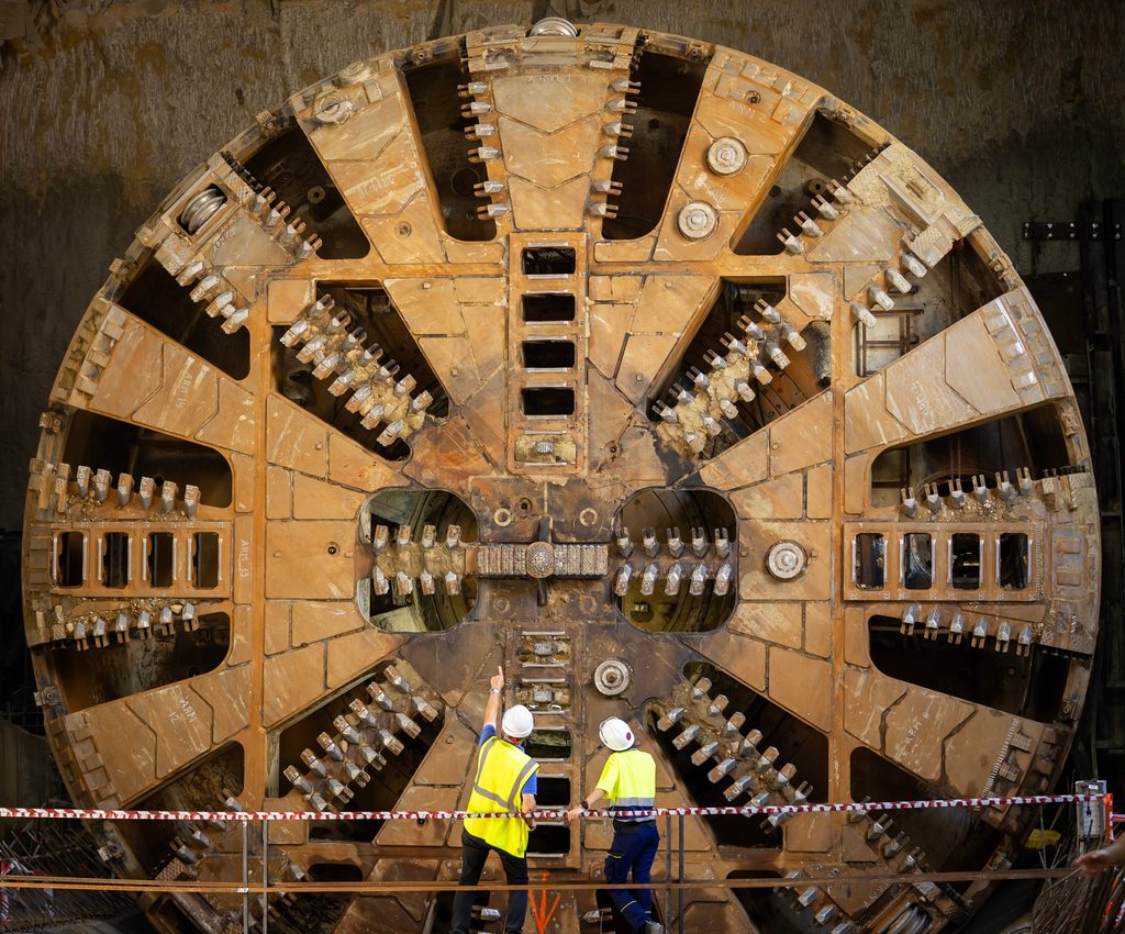  Workers inspect a tunnel boring machine